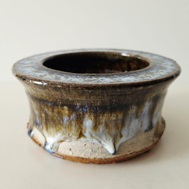 A beautiful round Scandinavian ceramic bowl in the Mid-Century Modern style, with a brown base glaze and a blue and white...