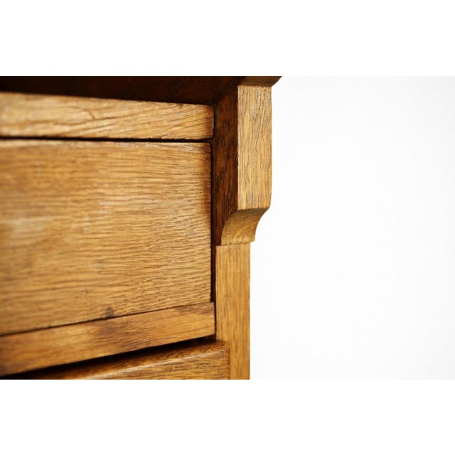 This antique cabinet was manufactured in England in first half of the 20th century. It is made from solid oak wood. It has...