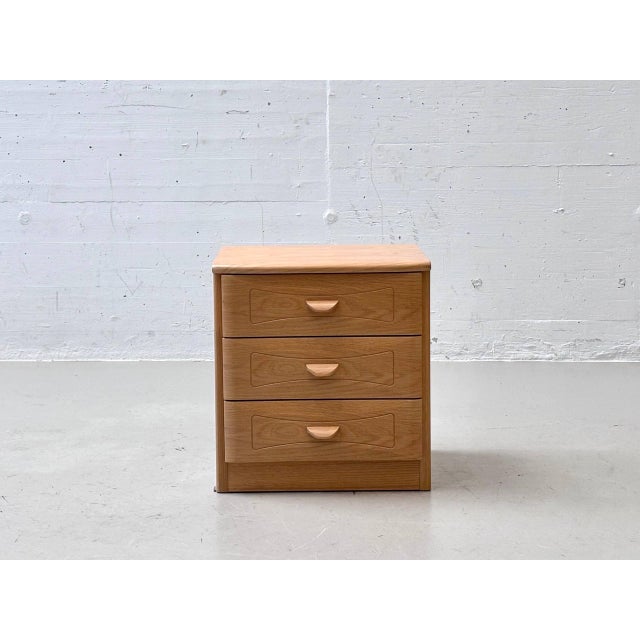 A beautifully designed vintage nightstand with three spacious drawers and a warm, light wood finish. The clean, compact...