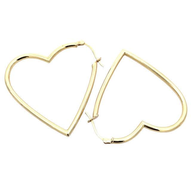 Elegant and playful, these 18K yellow gold large heart-shaped hoop earrings feature a sleek, polished finish with a...