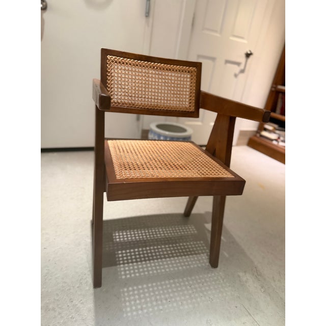 Sculptural vintage wood and woven cane armchair with warm chestnut-brown tones and distinctive architectural lines. The...