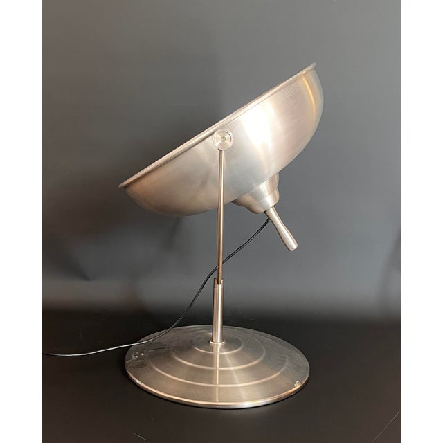 Large lamp made entirely of brushed aluminum, can be adjusted to different positions and is turned on with a foot pedal....