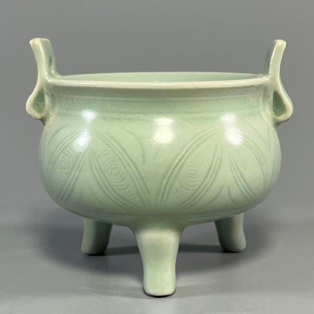 This is a Chinese Longquan celadon tripod censer with twin upright handles. Adopting classic ancient bronze ding shape,...