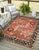 A hand-knotted wool rug, made in India and measuring 7'7"' x 9'11"'. Floral drawing carried across the field inside a...