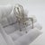 This vintage silver decorative object depicts an elegant chair figurine miniature, crafted as a dollhouse centerpiece,...