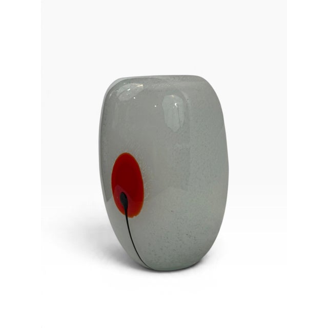 A quiet, sculptural studio art-glass vase in satin-frosted white glass, decorated with a single red poppy-like bloom on a...