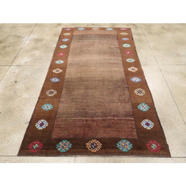 This mid-20th century Turkish Anatolian gallery carpet, measuring 5' 11" x 10' 10", features a strikingly minimalist field...
