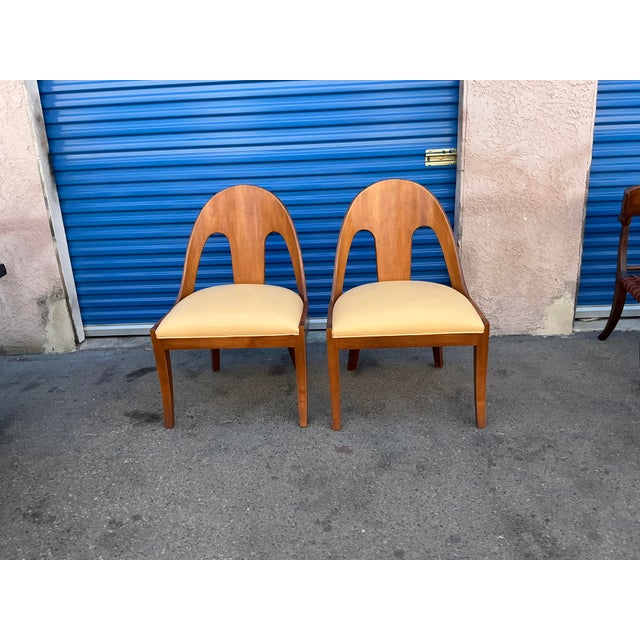 Pair of walnut spoonback chairs. The modern chairs are in good condition. The frames are solid. The upholstery is new,...