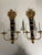 This is a pair of mid-century Italian made decorative two-light electrical wall sconces with black lacquered gilt wood...