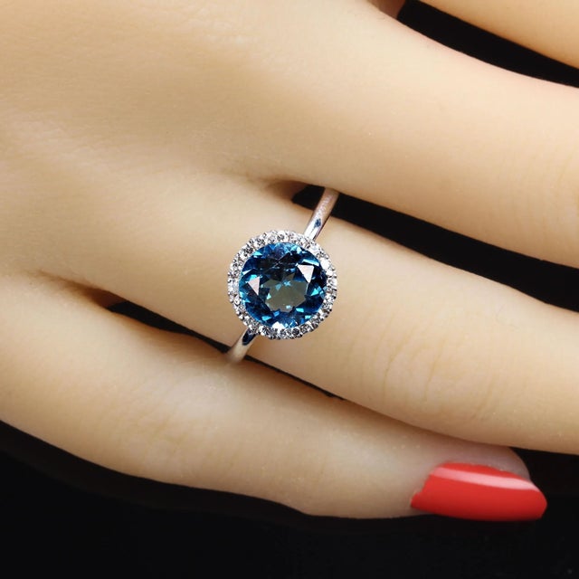 This is part of Chairish’s Fine Jewelry assortment. Stunning Blue Topaz and Diamond Halo Ring in 14K White Gold Elevate...