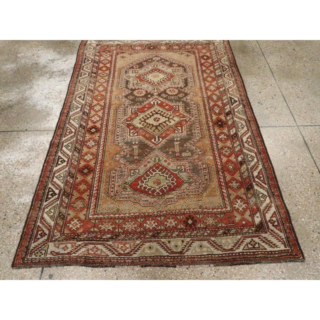 This early 20th-century Persian Afshar rug presents a bold tribal composition centered on three vertically aligned...