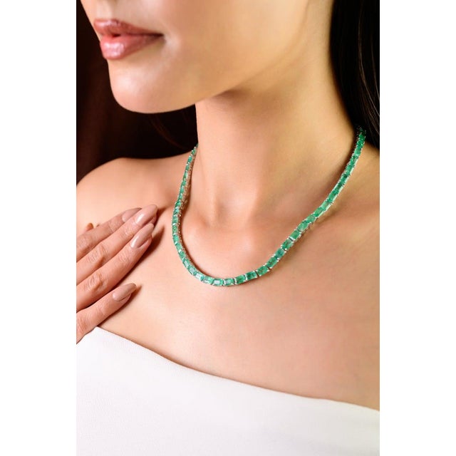 This tennis necklace features a seamless row of natural emeralds that radiate timeless sophistication. Set with 63...
