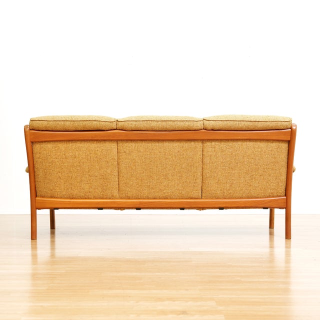 A stylish three seater sofa by Dyrlund of Denmark. With an elegantly designed frame the fresh ochre upholstery compliments...