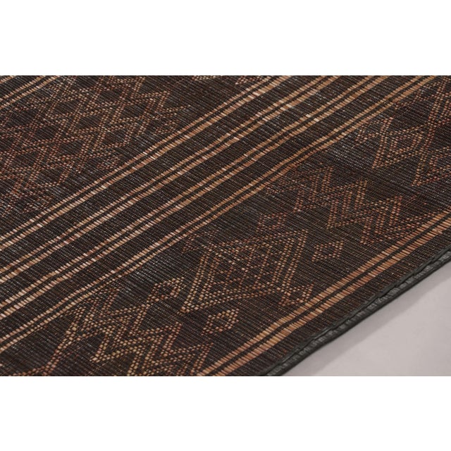 Made with handwoven reed and camel leather in Mauritania circa 1950-1960, this 5x8 vintage Tuarage mat is an exceptional...