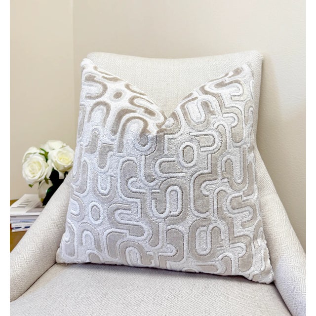 This pillow features a sculptural pattern of ivory and beige velvet shapes over a textured white bouclé background. The...