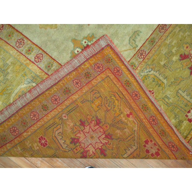 An early 20th century square size antique Turkish Oushak featuring an-all over design in warm colors. Measures: 12' x...