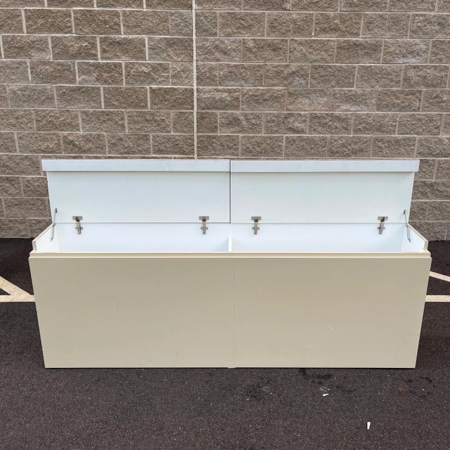 A late 20th century Postmodern 82" divided waterfall storage footboard or blanket chest in cream colored laminate with...