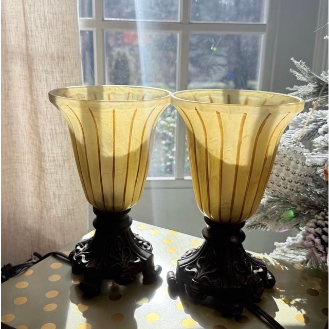 vintage Ting Shen hollow light-up table lamps feature amber-yellow ribbed glass shades paired with ornate, dark metal...