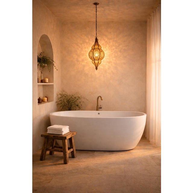 Beautiful vintage Moorish brass hanging lantern with yellow glow from the interior which is painted. The exterior is...