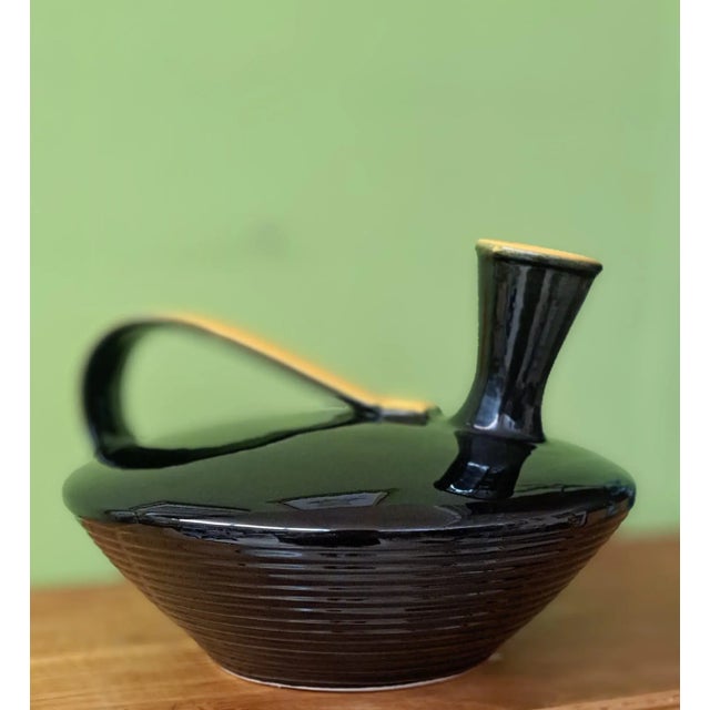 Elegant black ceramic jug or pitcher by Rometti Umbertide. This ceramic piece features a distinctive design, characterized...