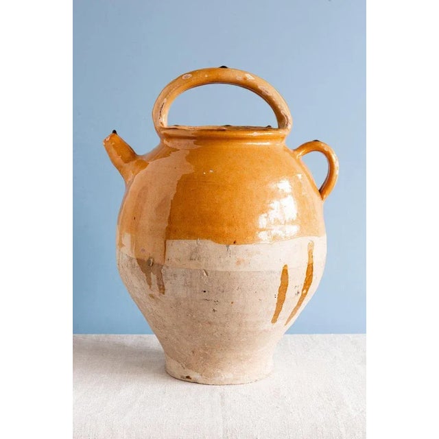This 19th-century French pottery jug from Provence is decorated in a gorgeous ochre glaze and bare clay on the lower part....