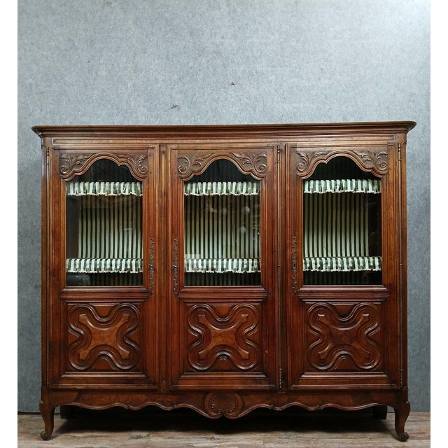 Important louis xv style walnut bookcase, circa 1850-1880. front opening with three carved, molded, and glazed doors....