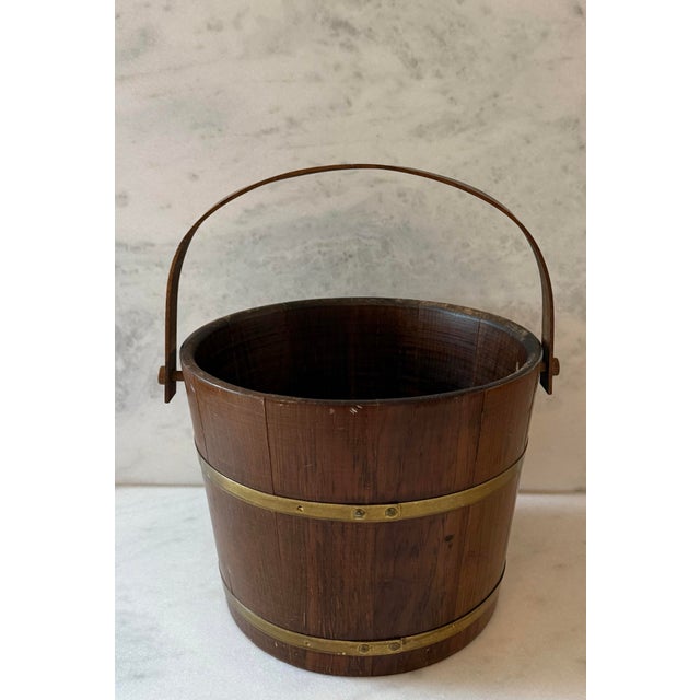 Vintage coopered oak and brass barrel bucket with bent wood swing handle. Staves are bound by two wide brass bands that...