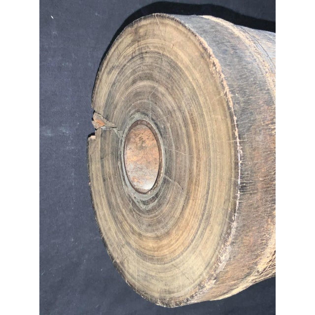 An antique wagon wheel axel sculpture on a custom iron stand . Product Information: Materials: Wood, Iron Dimensions: 11”...