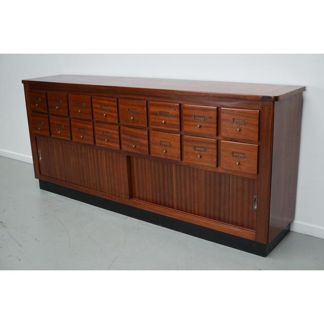 This cabinet was produced during the 1950/60s in the Netherlands. It features 16 drawers in quality hardwood and a two...