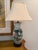 Painted porcelain lamps featuring flowers, deer, and cranes on their fronts. The back side of each lamp is decorated with...