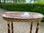 A refined 1970 French Louis XVI–style side table, handcrafted from solid mahogany with a natural marble top and finely...