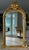 French Louis XV-style arched giltwood wall mirror. This striking piece beautifully captures the fluid asymmetry and...