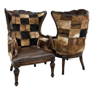 Vintage Carved Wood Patchwork Cowhide Wingback Chairs - Pair For Sale