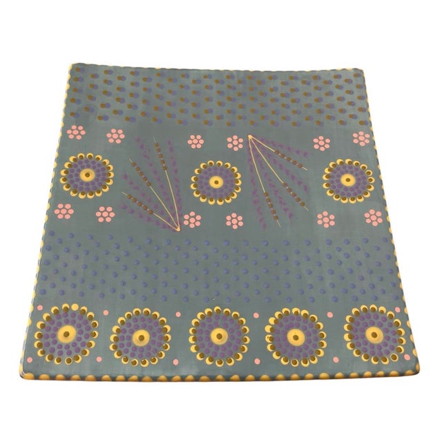 This large, square ceramic plate showcases a masterful display of South African artisanal craftsmanship, entirely hand-...