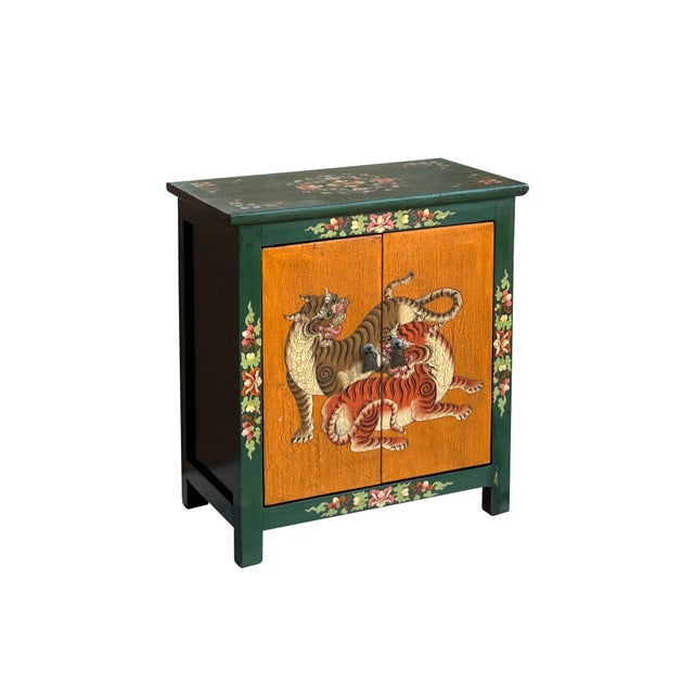 This eye-catching wooden cabinet features a vibrant, hand-painted aesthetic rooted in Tibetan or Himalayan folk art...