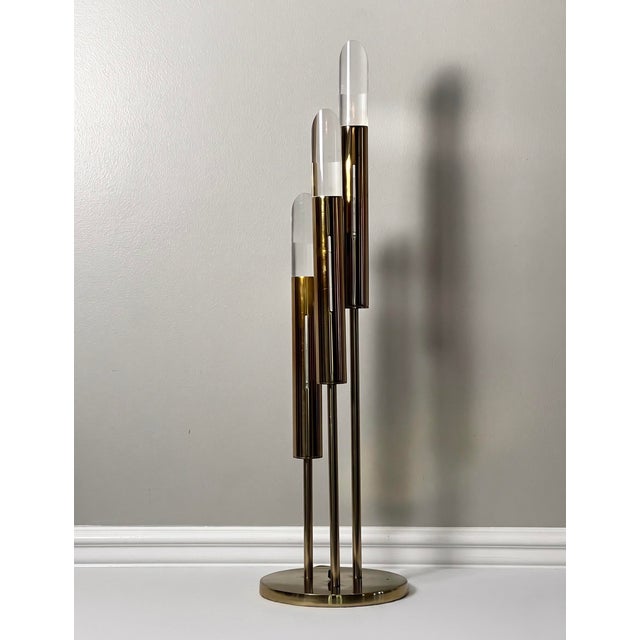 Striking modern three-light table lamp in brass plated metal and Lucite on a circular brass base by Laurel Lamp Company,...