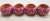 This is a set of four red wooden napkin rings decorated with white stars. Dimensions are: 2.5 by 3 inches.