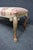 Queen Anne style upholstered bench in cherry wood. Features cabriole legs with carved and gilt-accented detailing and a...