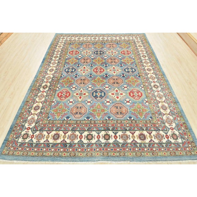 A traditional tribal Caucasian Kazak rug hand-knotted with an all-wool pile on a cotton foundation. This oriental rug...