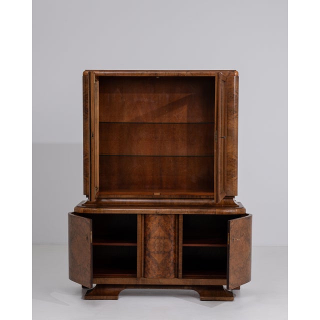 A striking Art Deco display cabinet characterized by geometric lines and balanced proportions. The glazed sections provide...