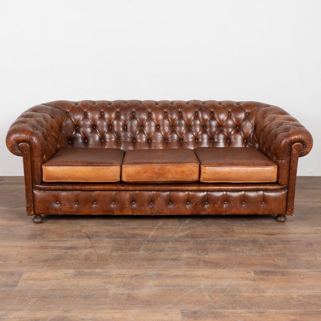 20th century Spanish brown leather Chesterfield sofa. Classic Chesterfield form with rolled arms, tufted button back, and...
