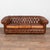 20th century Spanish brown leather Chesterfield sofa. Classic Chesterfield form with rolled arms, tufted button back, and...