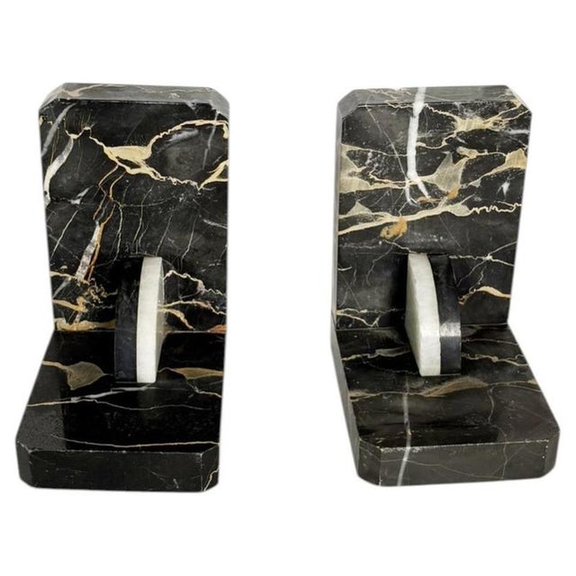 An elegant pair of bookends crafted from black marble veined with white and beige, featuring a clean, timeless geometric...