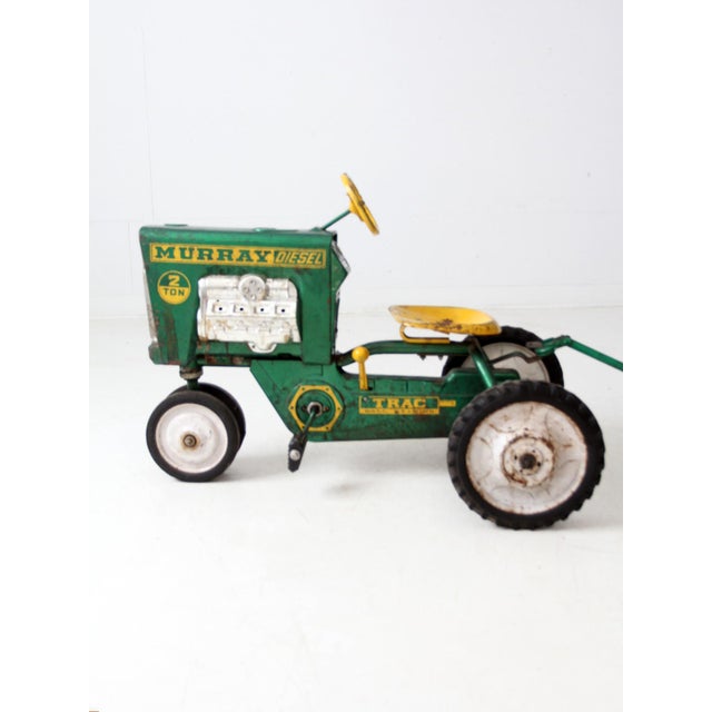 This mid-century Murray Diesel pedal tractor features bold green and yellow paint, “Trac Ball Bearing” markings, and an...