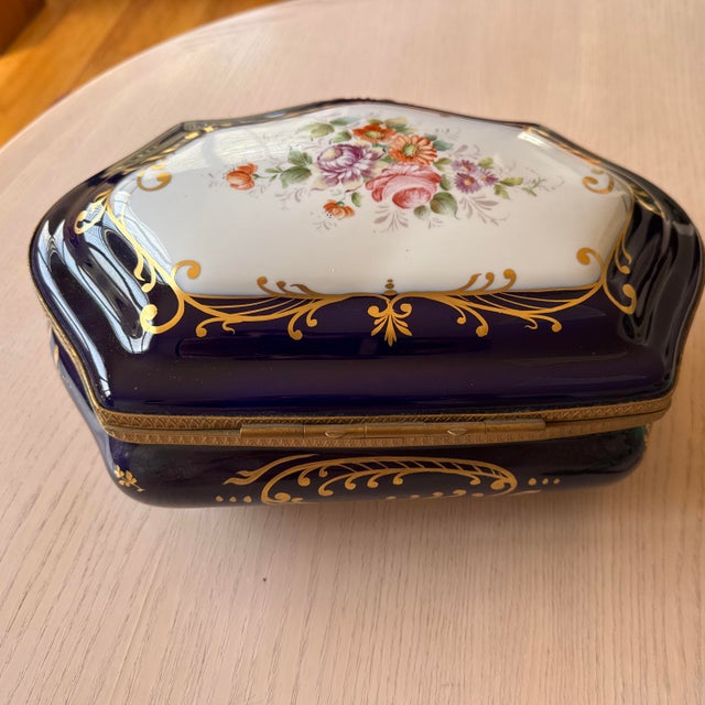 This vintage hand-painted porcelain extra large jewelry box is of French origin. The design characteristics—cobalt blue...