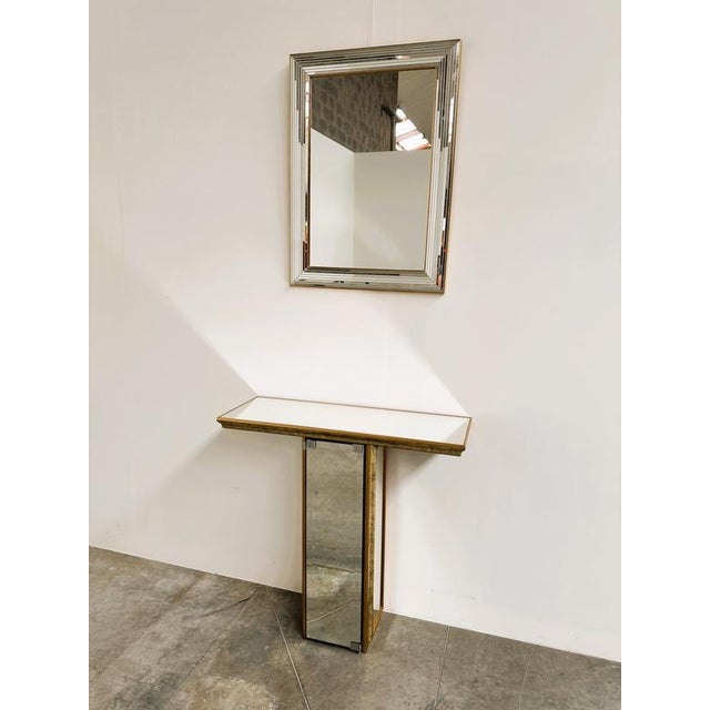 A highly decorative vintage mirrored console by Deknudt, Belgium, combining Hollywood Regency glamour with clever...