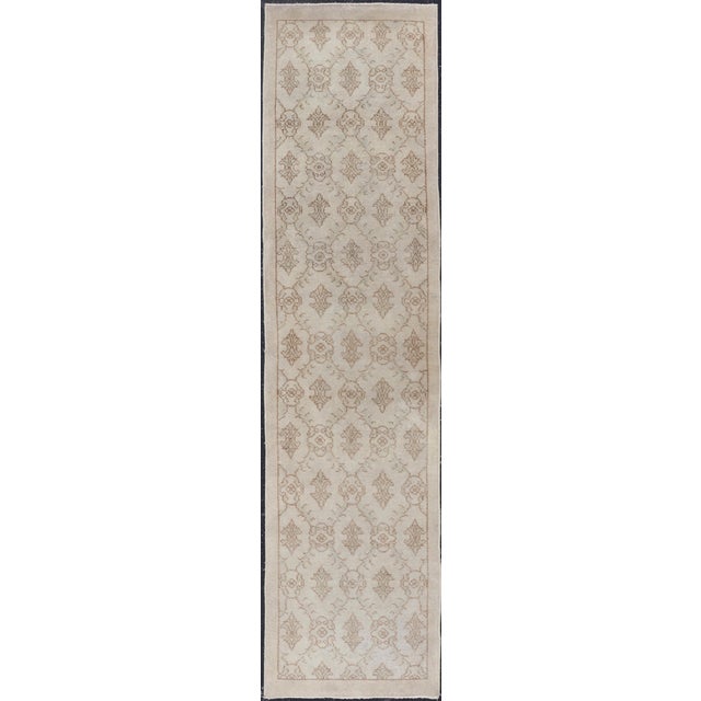 This vintage Turkish Oushak runner (circa mid-20th century) features an all-over latticework design with arrowhead figures...
