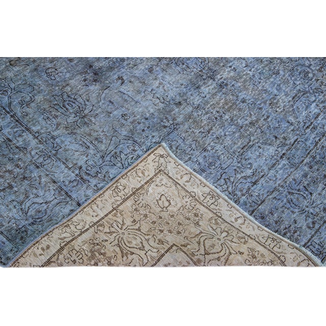 Beautiful Vintage Overdyed hand-knotted wool rug with a blue field. This Persian rug has an all-over design. This rug...