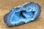 Distinguished by vivid concentric chalcedony banding and an open crystalline cavern, this natural blue agate quartz geode...