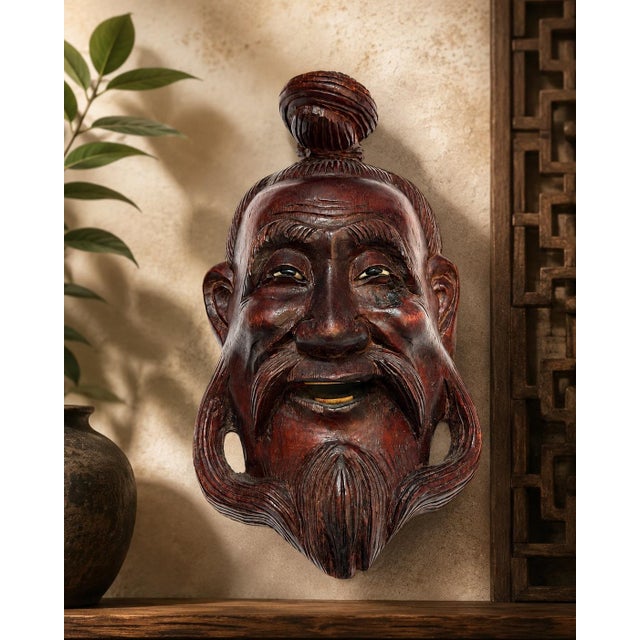 A wonderfully expressive vintage Chinese hand-carved hardwood wall mask depicting a smiling sage or elder. Full of...
